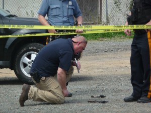 An investigator checks out two guns that were dropped near the scene of the shooting on Martin Luther King Jr. Blvd. on Tuesday. Trentonian Photo/PENNY RAY