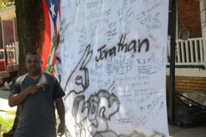 Jonathan's brother Humberto Jimenez stands next to a makeshift memorial in the first block of Cummings Avenue (Penny Ray - Trentonian) 