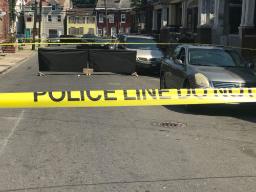 A murder victim lies in the street on Sanford St in Trenton Friday as police process the scene. John Berry - The Trentonian